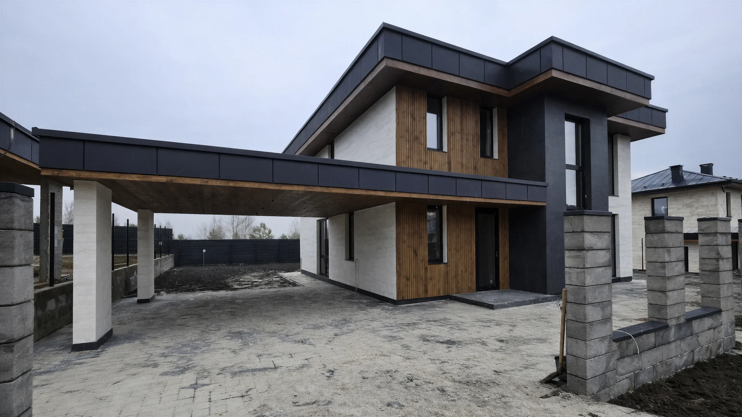 Боковой фасад построенного каменного дома 240 м² с большими окнами