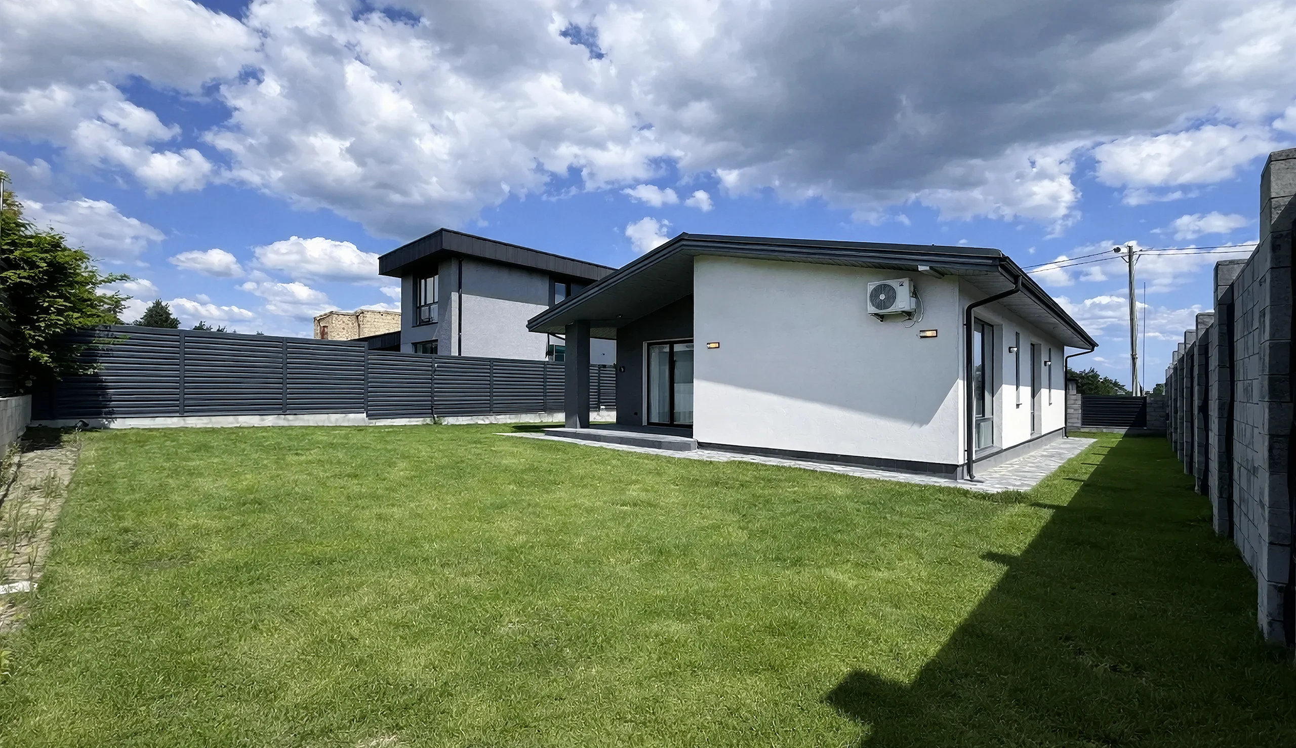 Реализованный фасад построенного дома 125 м² с кровлей и окнами