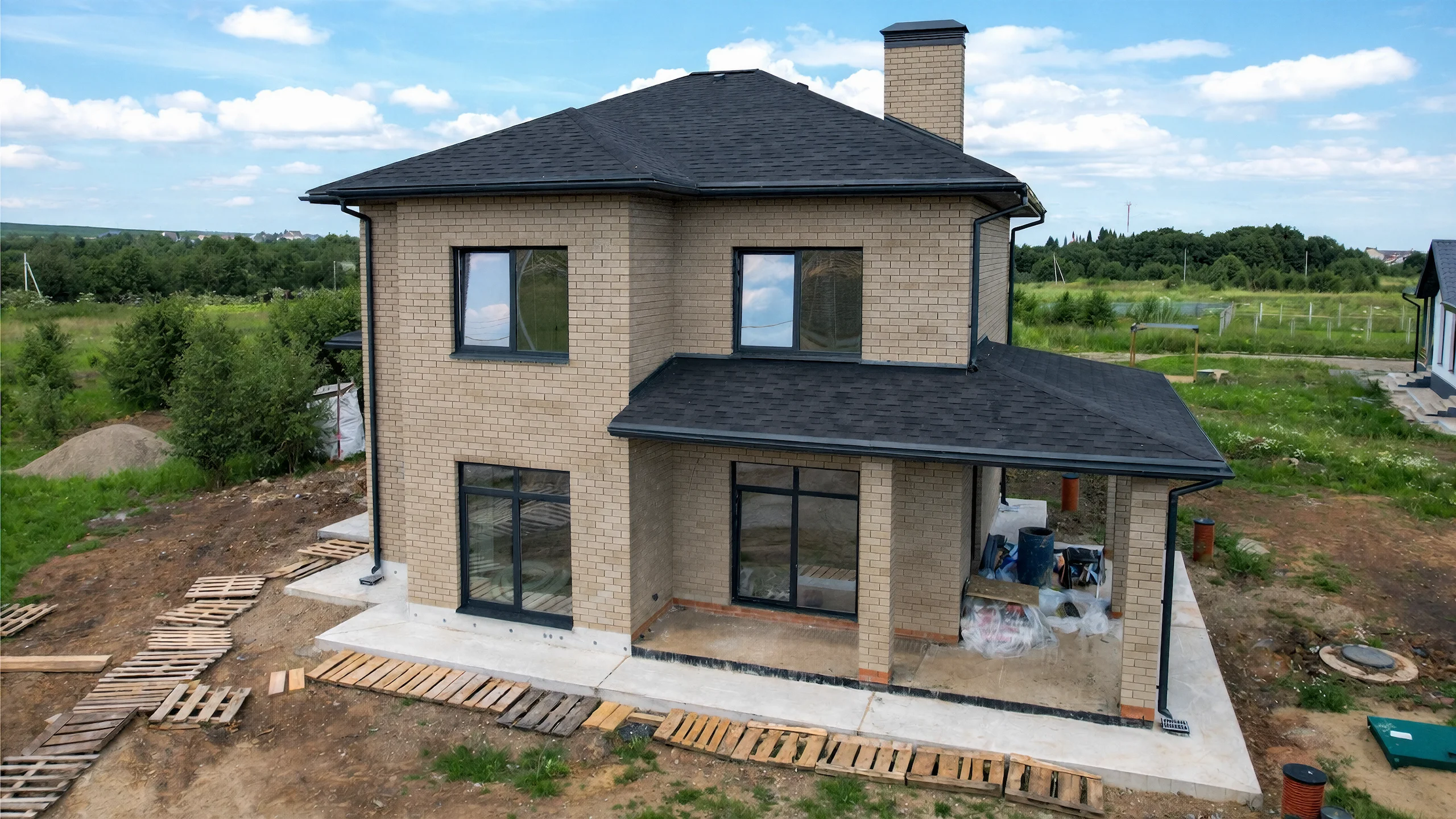 Реализованный фасад построенного дома 155 м² с кровлей и окнами