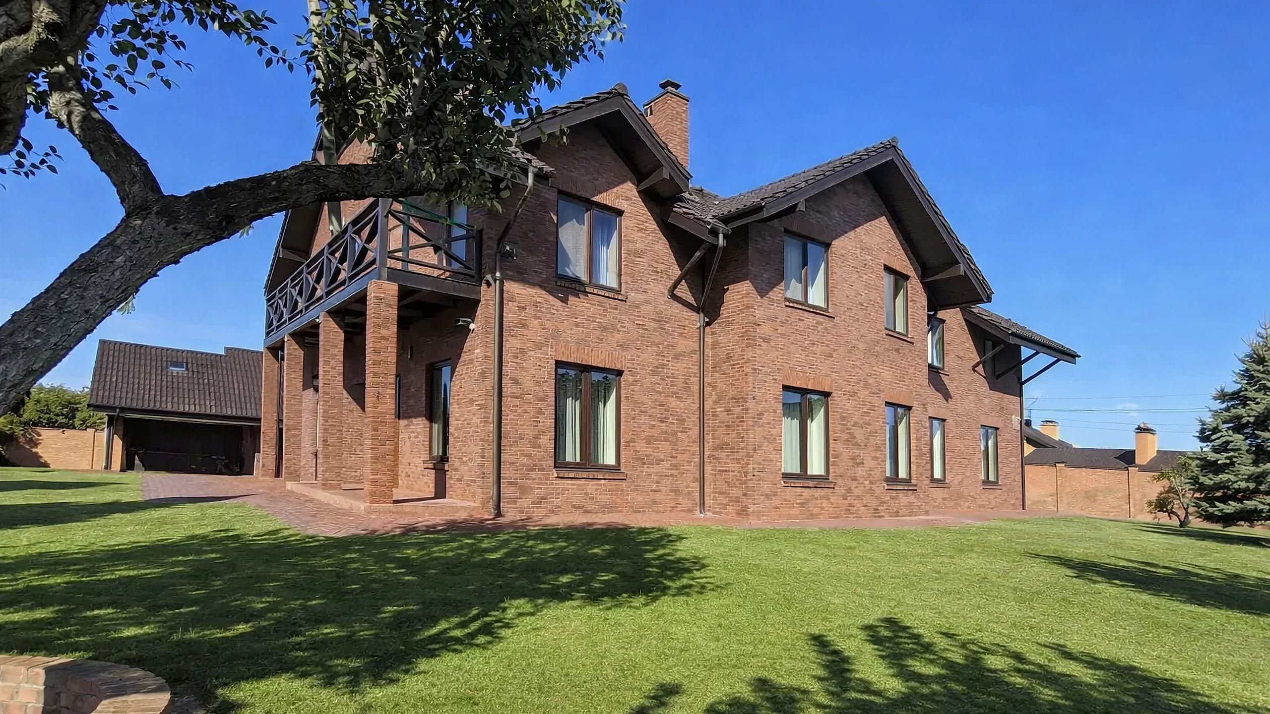 Боковой фасад построенного каменного дома 499 м² с большими окнами